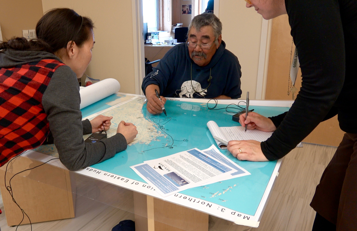 Photo Courtesy of Meghan Sheremata (right) Eliasee Weetaluktuk (elder, centre) and Laura Iqaluk (interpreter, left) in an interview in 2017 in Inukjuak, Nunavik